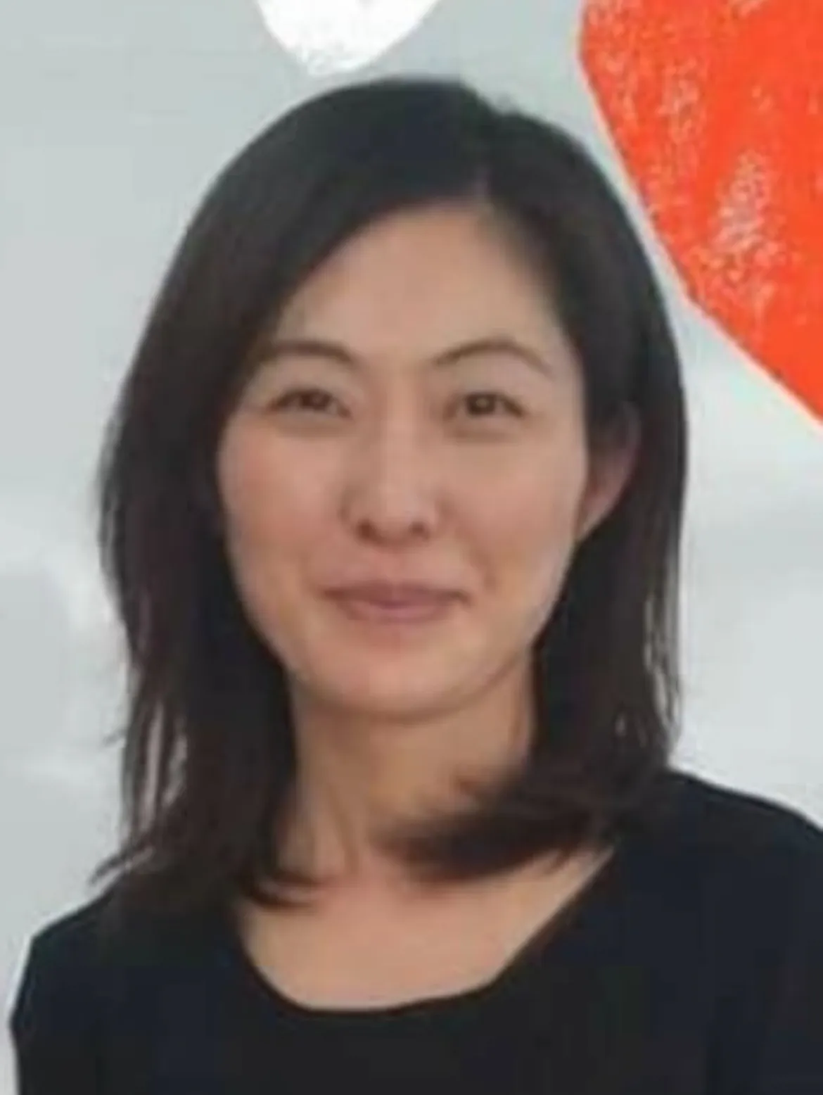 写真:肩までの長さの黒髪の女性が笑顔で写っている